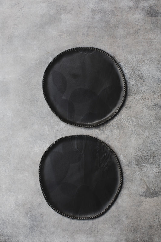 black ceramic plates with textured rims handmade by clay beehive