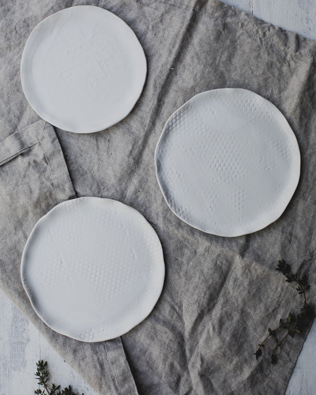 satin white plates with a lovely textured surface created by clay beehive ceramics
