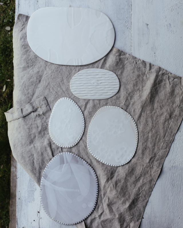 satin white flat plates with textures hand crafted by clay beehive ceramics