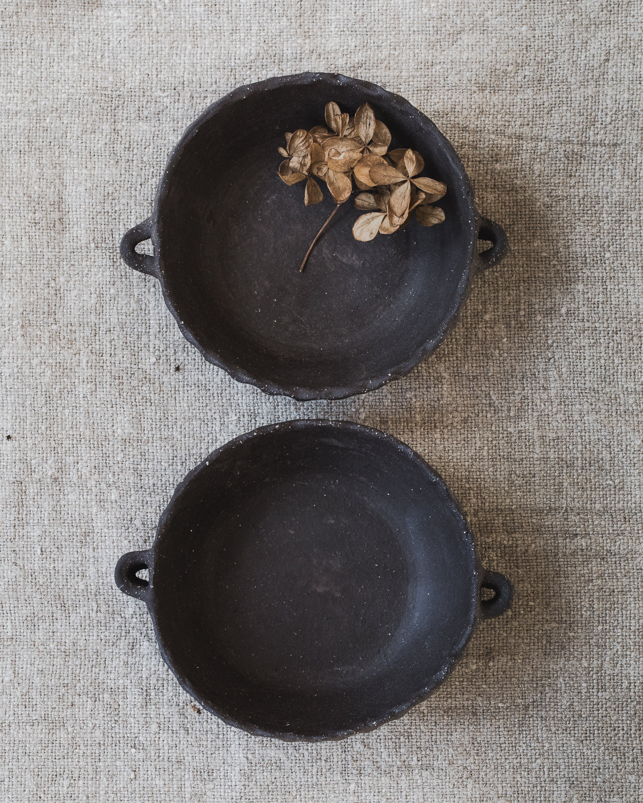 Handmade matte black rectangular fluted bowls with little handles handmade by clay beehive ceramics.