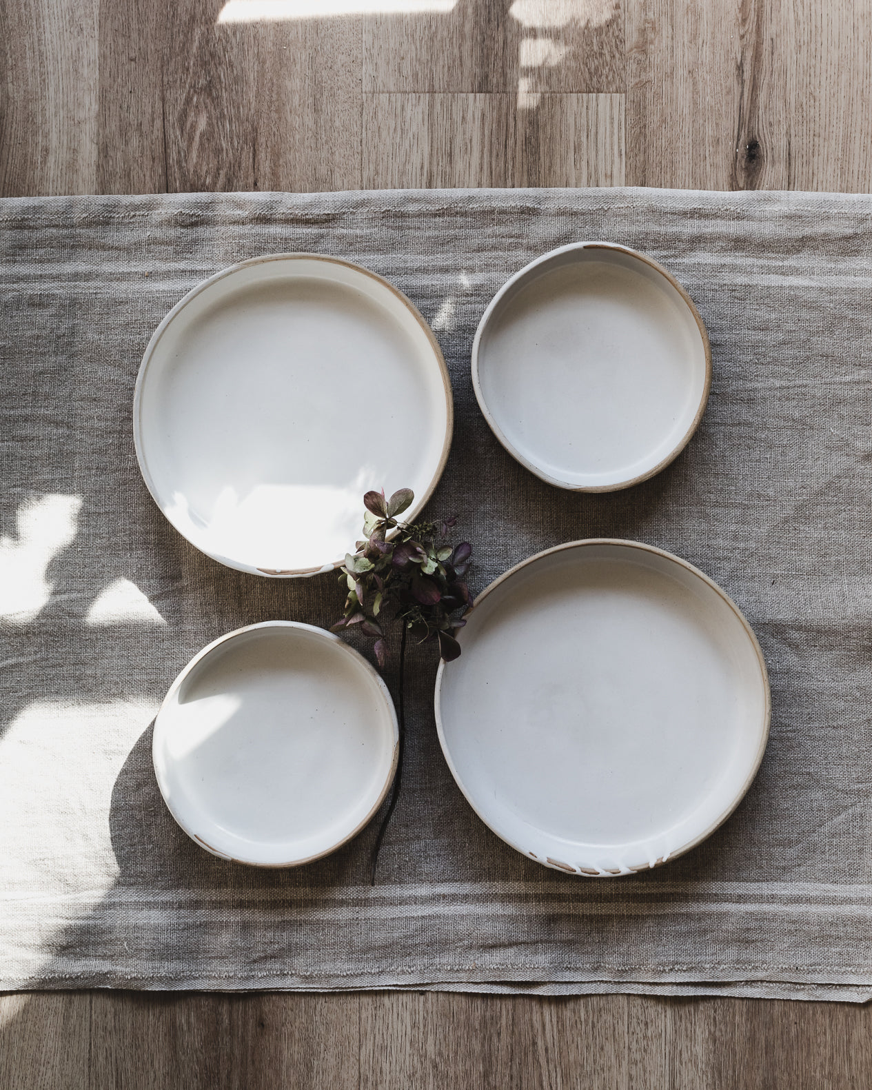 Deep dish plates handmade with a tan/speckled clay and glazed in a drippy satin white finish, created by clay beehive ceramics