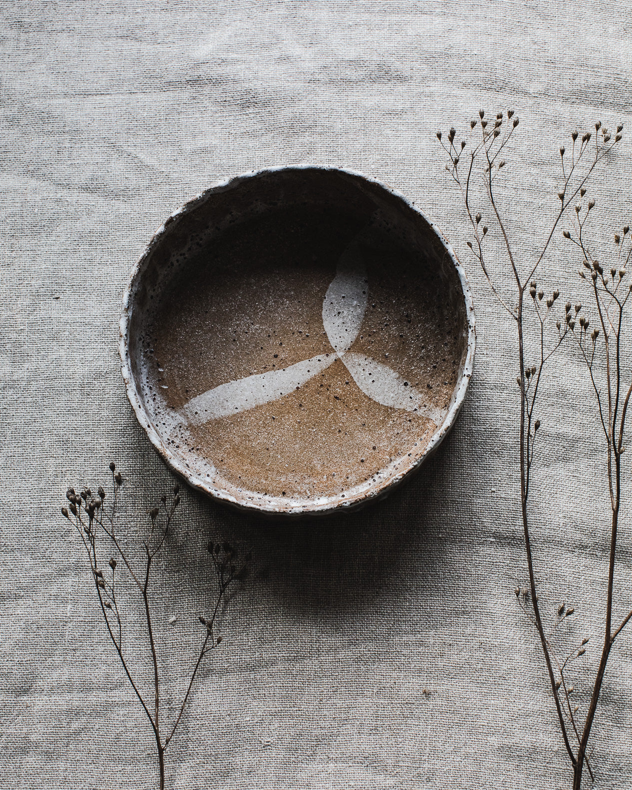 Deep bowl/plate with textured fluted surface design, created with a beautiful warm chocolate clay and glazed in a drippy white exterior finish, handcrafted by Clay Beehive ceramics. 