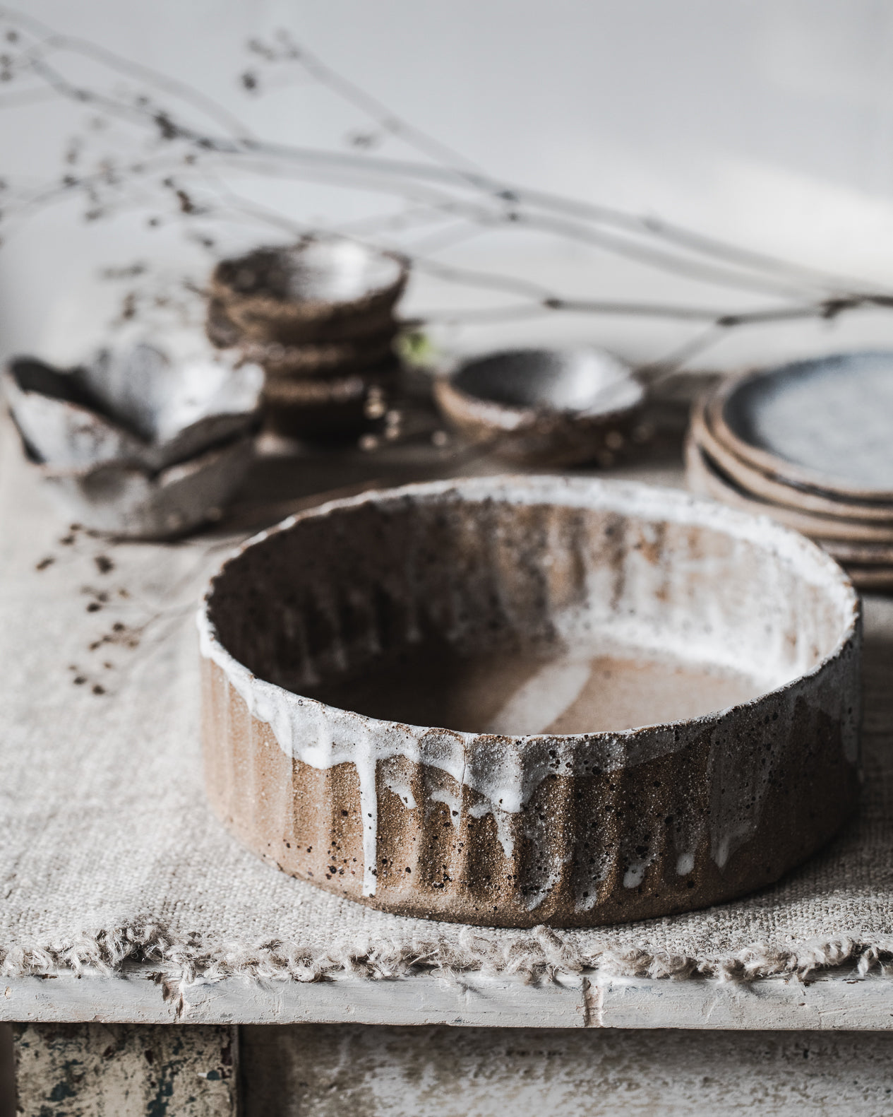 Deep bowl/plate with textured fluted surface design, created with a beautiful warm chocolate clay and glazed in a drippy white exterior finish, handcrafted by Clay Beehive ceramics. 