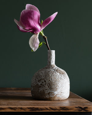 Large bottle shaped textured vase with long neck, glazed in a matte white finish, contrasting against the rustic speckled tan clay body, handmade by Clay Beehive ceramics. 