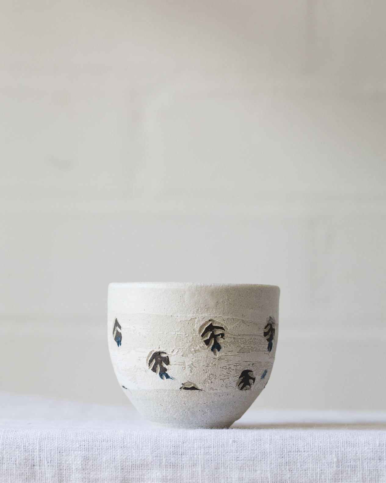 Footed white cups with decorative surface design