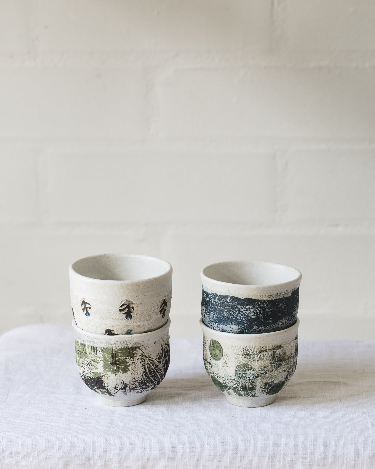 Footed white cups with decorative surface design