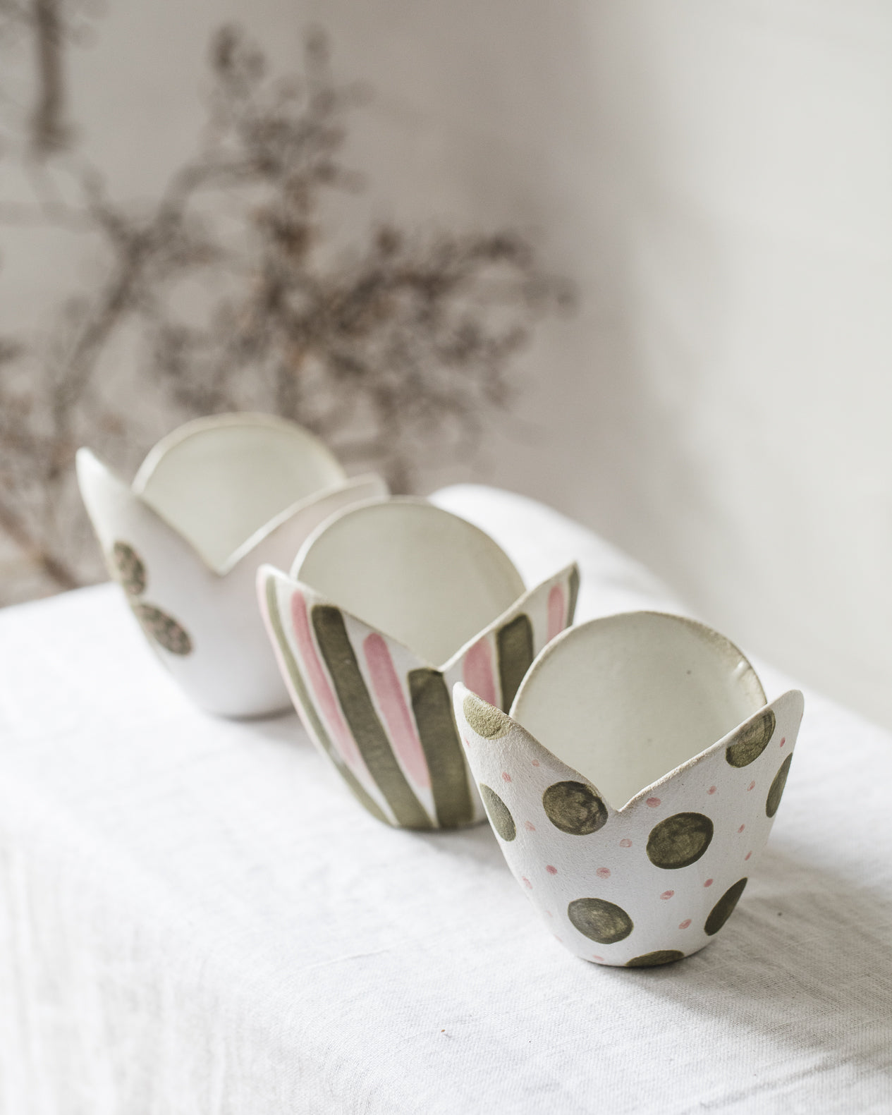 tulip shaped ceramic bowls with spots, flowers and line decorations in pink and green, handmade by clay beehive ceramics