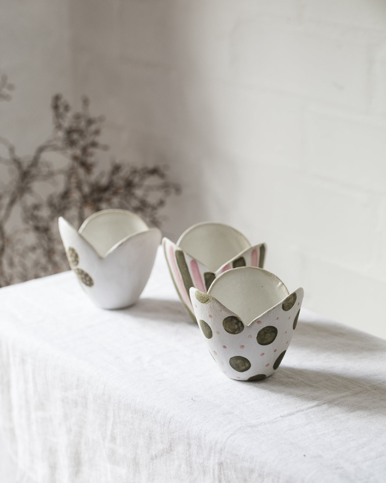 tulip shaped ceramic bowls with spots, flowers and line decorations in pink and green, handmade by clay beehive ceramics