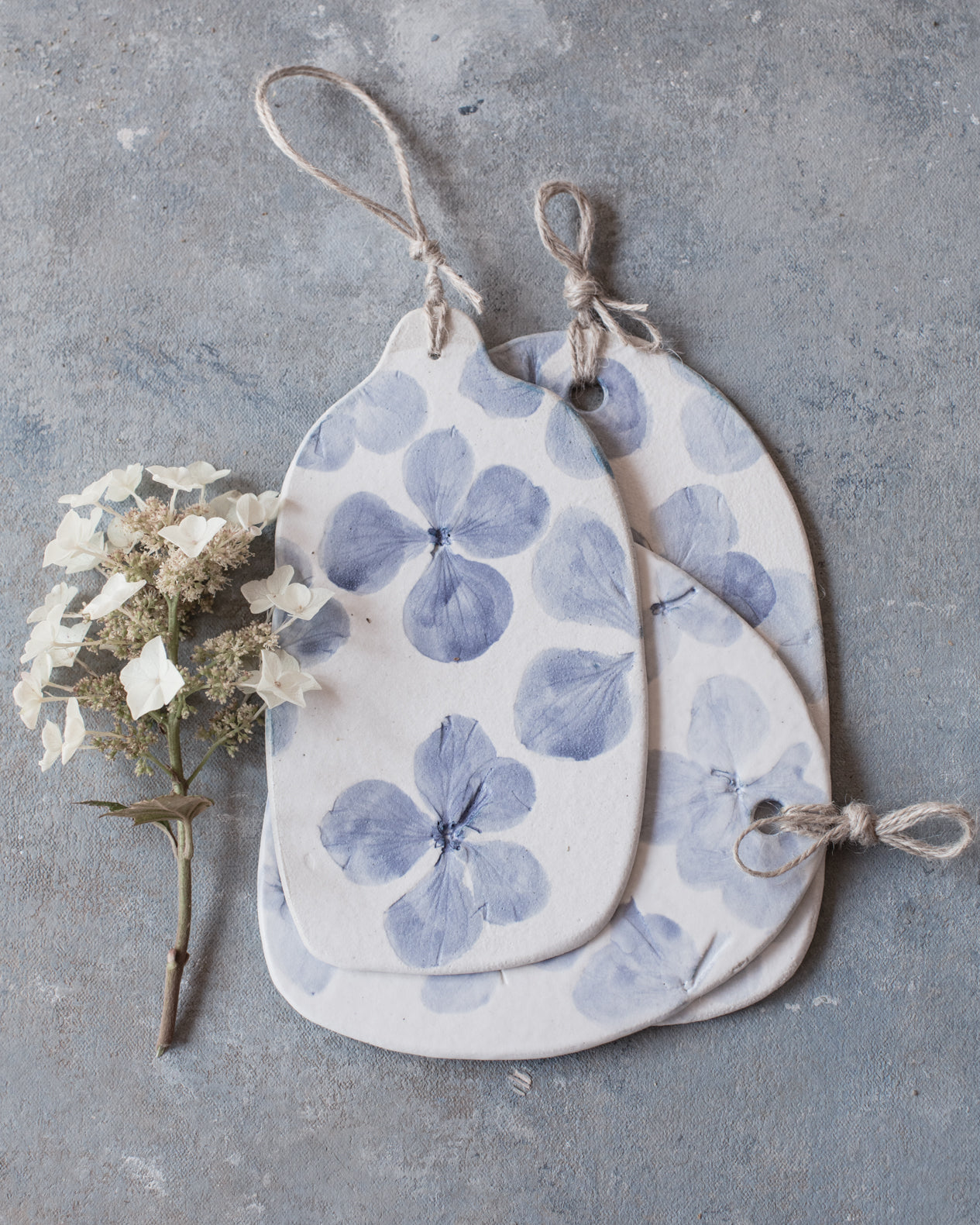 Hydrangea flowers impressions painted blue on clay beehive cheeseboards with hemp cord
