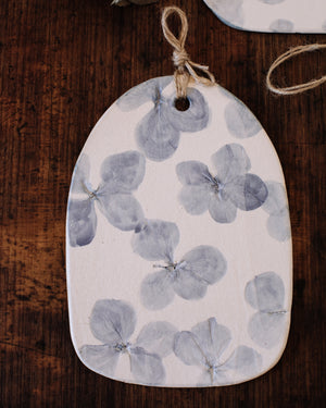 Hydrangea flowers impressions painted blue on clay beehive cheeseboards with hemp cord
