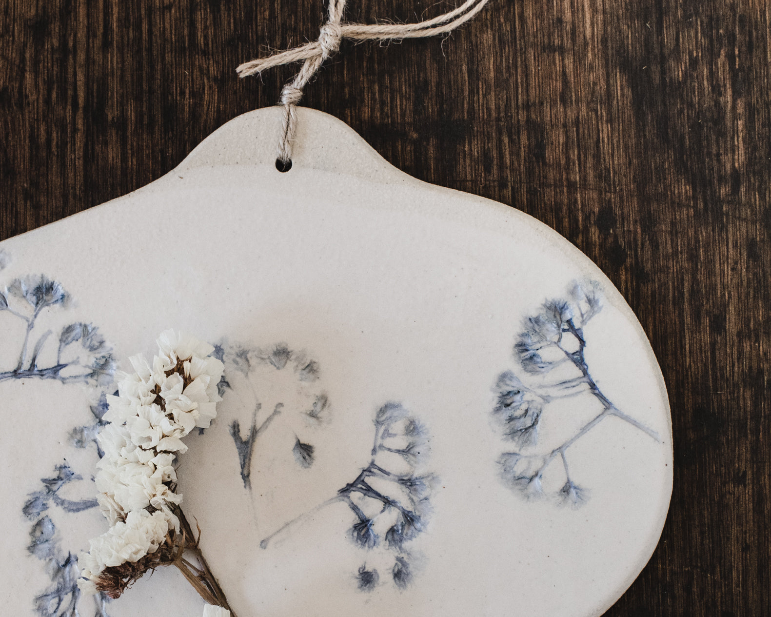 Ceramic cheeseboard with hemp cord decorated with impressed flower painted blue by clay beehive ceramics