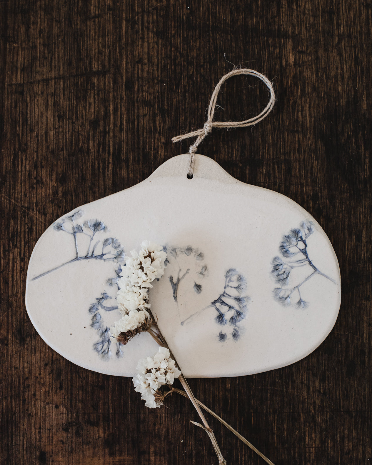 Ceramic cheeseboard with hemp cord decorated with impressed flower painted blue by clay beehive ceramics