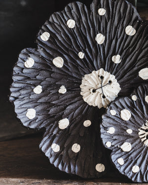 close up detail of carved ceramic flower with black and white spot handmade by clay beehive ceramics