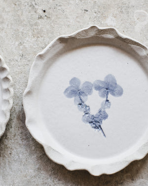 Handmade cake plates with blue and white painted designs including hydrangea flowers, anemone flowers and spots and tartan patterns by clay beehive ceramics