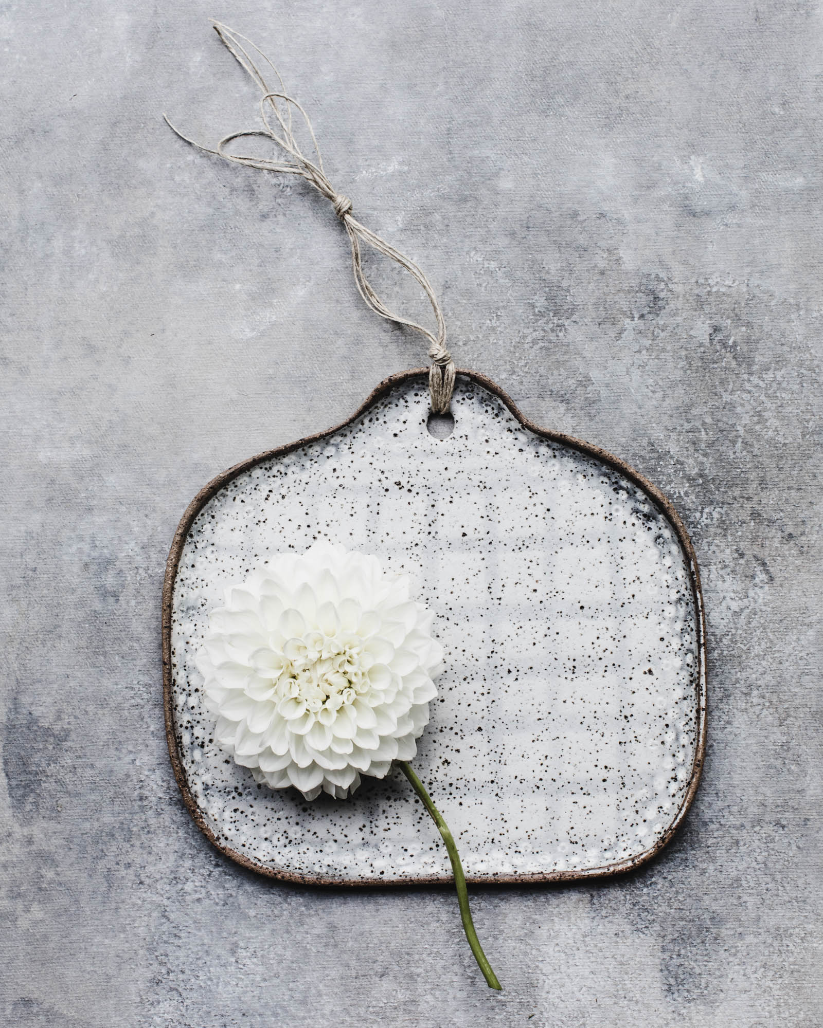 gritty rustic cheeseboard with tab handle and grid pattern handmade by clay beehive ceramics