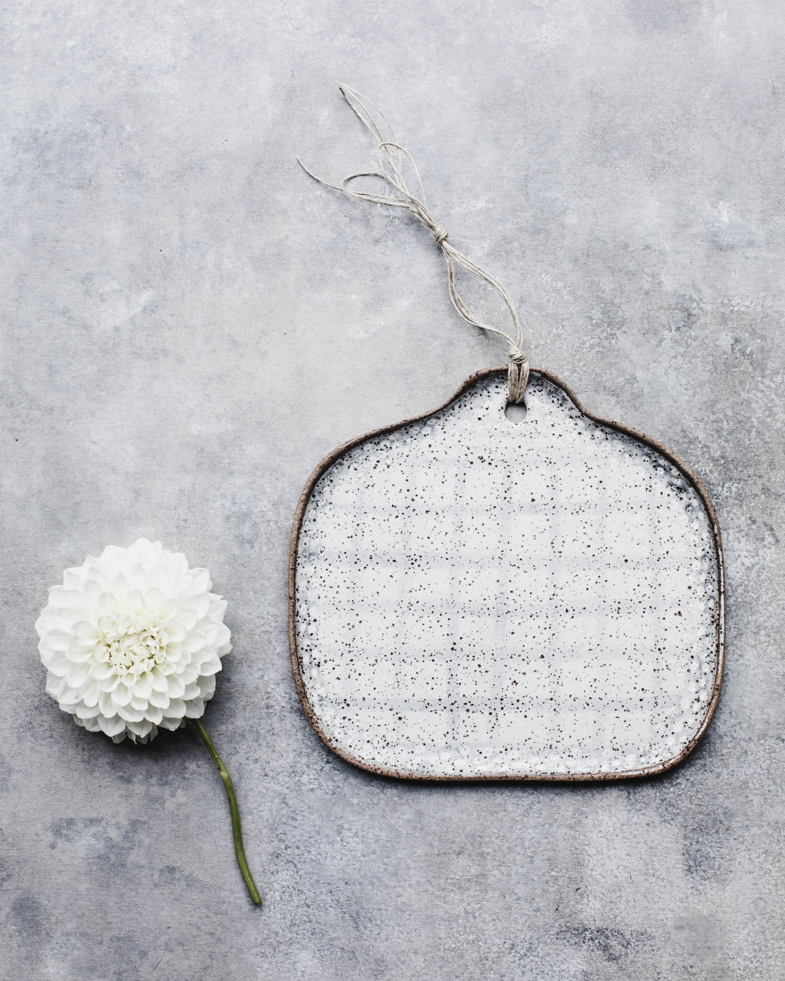gritty rustic cheeseboard with tab handle and grid pattern handmade by clay beehive ceramics