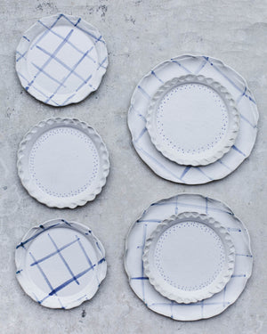 Satin white plates with earthy scallop shaped rims and blue and white finish handmade by clay beehive ceramic
