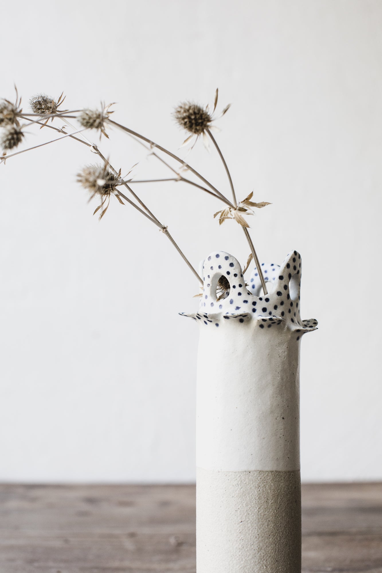 Ceramic vase with cutout circle scalloped rim and small blue spots by clay beehive ceramics