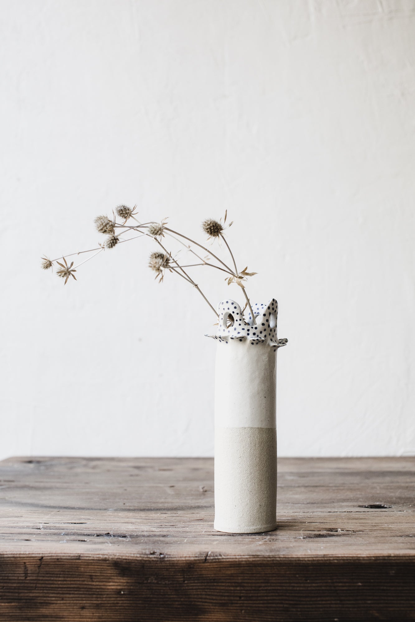 Ceramic vase with cutout circle scalloped rim and small blue spots by clay beehive ceramics