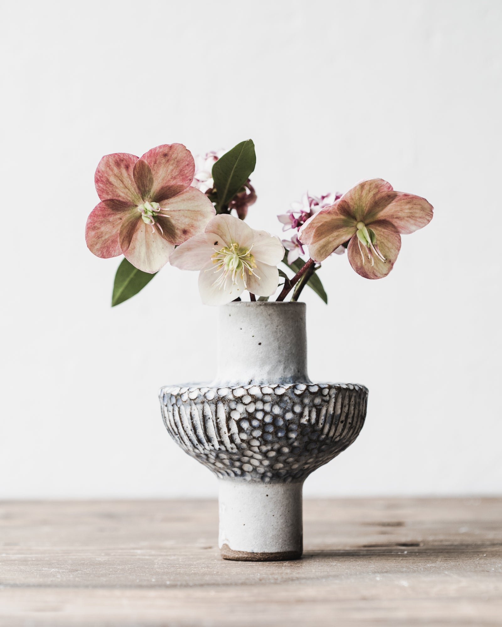 Pod bud vase with tall foot and spotty carved textured body in blue/white glaze handmade by clay beehive ceramics