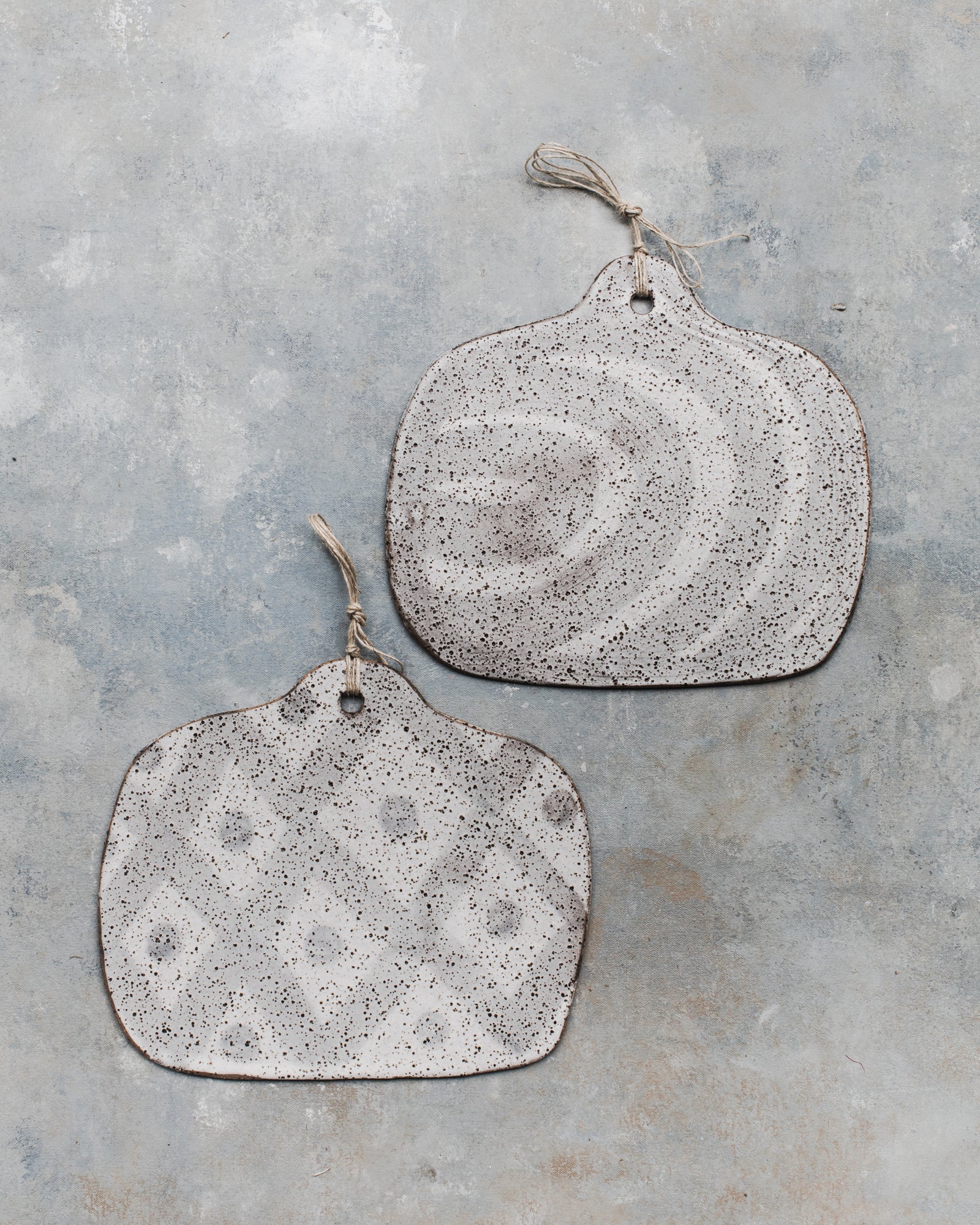 Handmade ceramic cheeseboards in a rustic speckled finish with hemp cord designed and created by clay beehive 