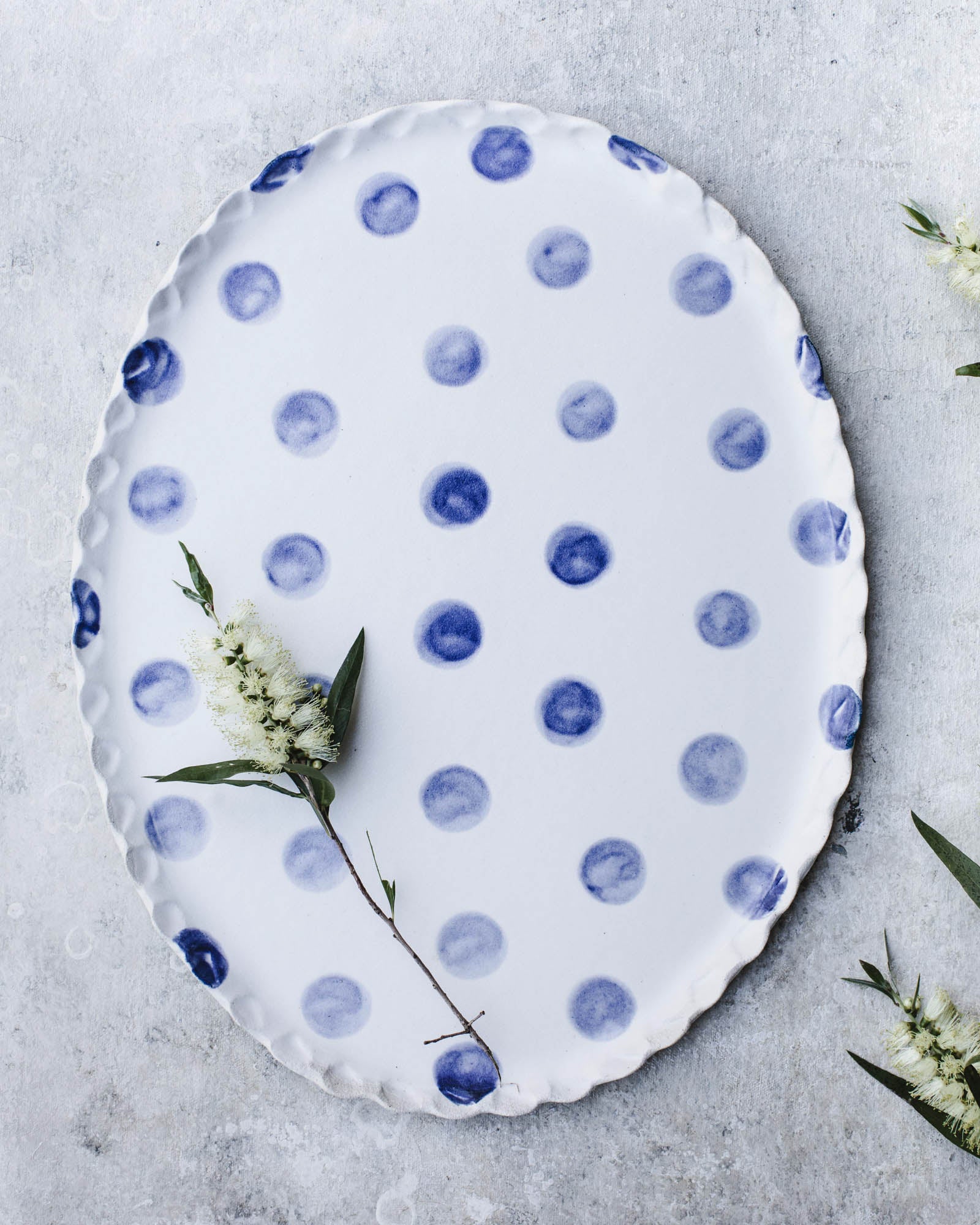 Large oval shaped navy blue polka dot platter with scallop rim by clay beehive ceramics