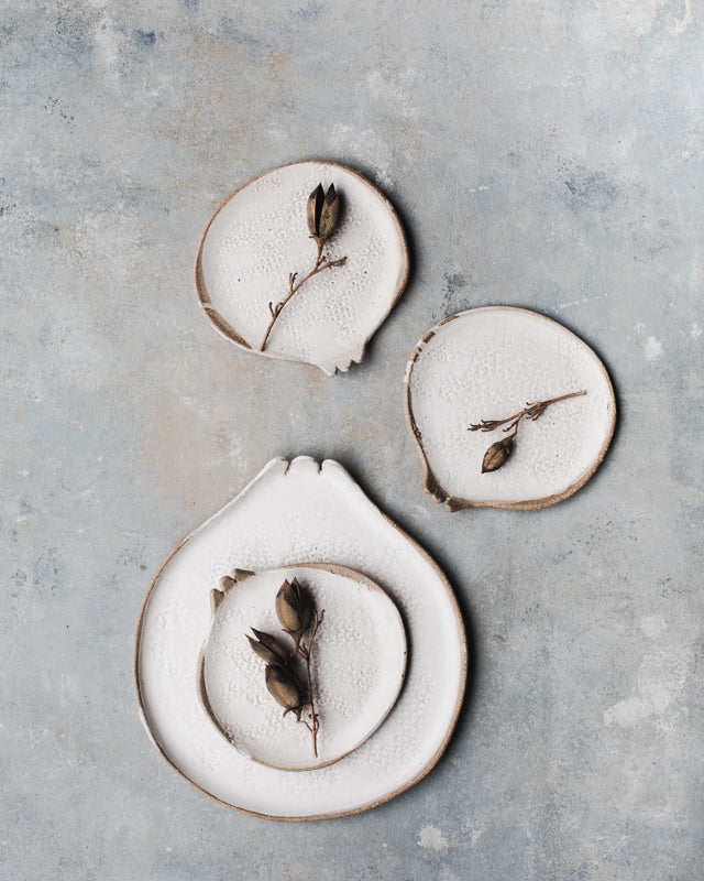 Pomegranate shaped plates in a satin white rustic finish with texture by clay beehive ceramics.