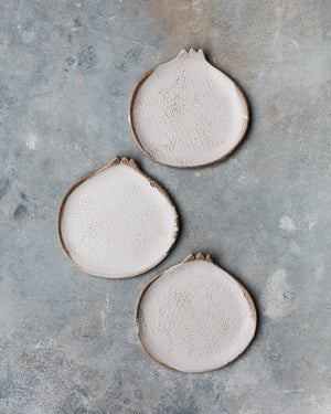 Pomegranate shaped plates in a satin white rustic finish with texture by clay beehive ceramics.