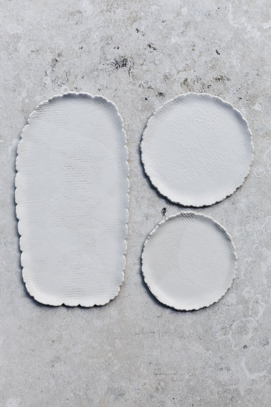 Textured satin white hand made plates with scalloped/textured rims by clay beehive