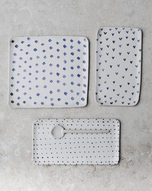 Selection of rectangular ceramic plates decorated in blue and white spots diamonds and hearts by clay beehive.