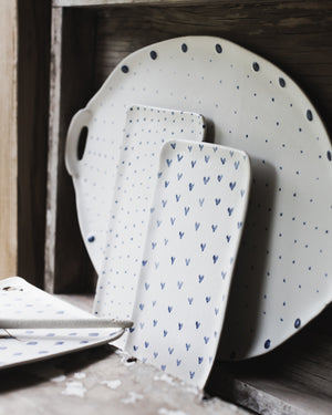 Selection of rectangular ceramic plates and large platter with handles decorated in blue and white spots diamonds and hearts by clay beehive.