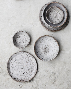 speckled white clay plates and bowls set by clay beehive ceramics