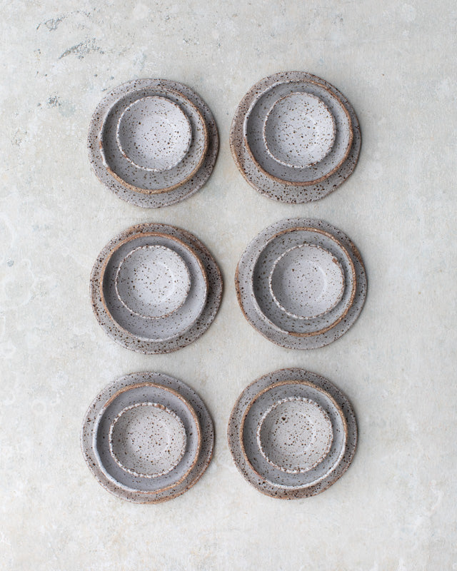 speckled white clay plates and bowls set by clay beehive ceramics
