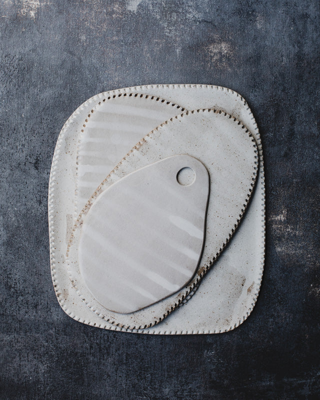 Platters and flat plates glazed in satin white over warm speckle clay body by clay beehive