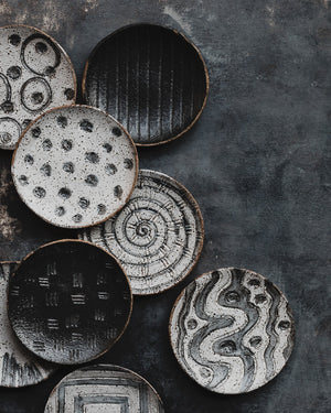 hand made ceramic rustic tapas sharing plates with carved designs glazed in satin black and white by clay beehive 