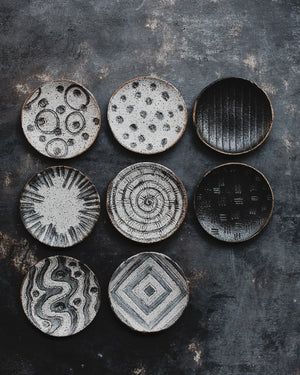 hand made ceramic rustic gritty tapas sharing plates with carved designs glazed in satin black and white by clay beehive 