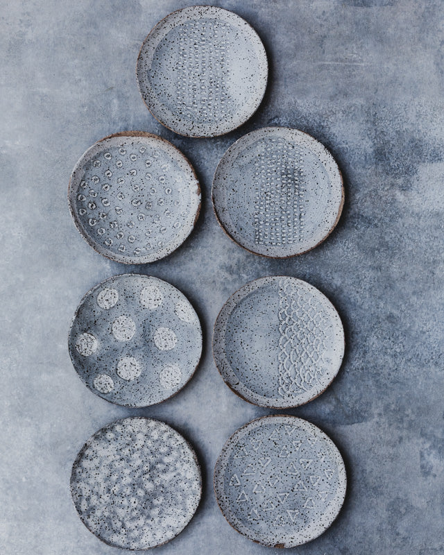 carved handmade ceramic plates in gray and white by clay beehive