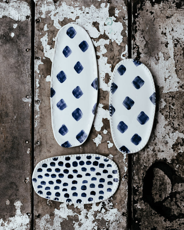 Small oval handmade ceramic plates in blue and white by clay beehive